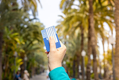 Personne tenant sa carte européenne d'assurance maladie dans sa main